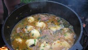 大釜で豚の火でシュルパのスープを作る